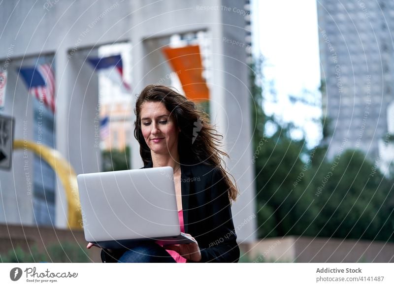 Geschäftsfrau mit Laptop auf der Straße in der Stadt Unternehmer Großstadt selbstbewusst Stadtbild formal gut gekleidet professionell Frau Business heiter