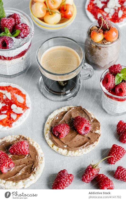 Chia-Pudding, serviert mit Knäckebrot und Kaffee Frühstück Beeren Marmelade Kirsche Himbeeren Scheibe Nut süß Aufstrich Erdnussbutter Mandelblättchen Glas Tasse