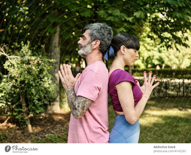 Paar macht zusammen Yoga in Berghaltung Berg-Pose tadasana Namaste Asana sich[Akk] entspannen Zusammensein Partnerschaft üben ruhig Gesundheit meditieren Park