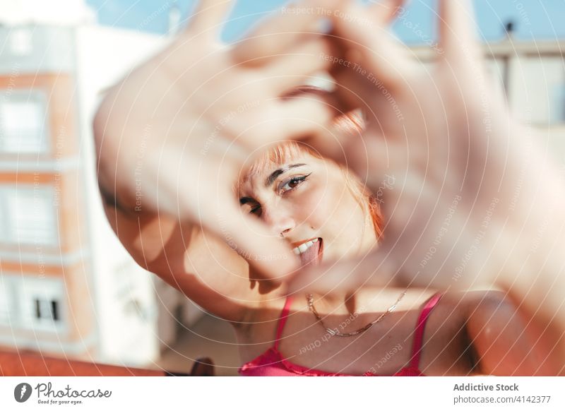 Junge Frau mit rosa Haaren in der Stadt tausendjährig Gesicht machen sorgenfrei anders Verhalten expressiv Stadtbild Grimasse kreativ modern trendy