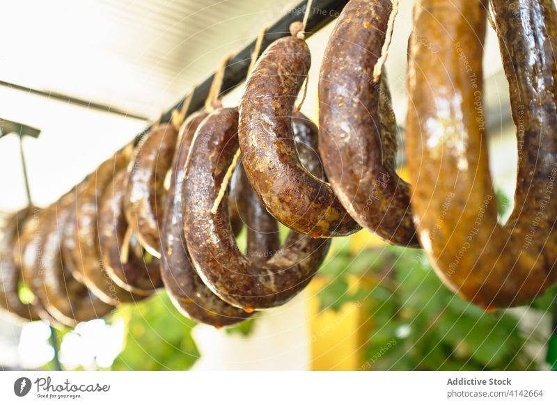 Frische Fleischwürste hängen auf einem Gestell und reifen Wurstwaren Ablage lokal Fabrik Chorizo selbstgemacht frisch Inszenierung Tradition Lebensmittel lecker