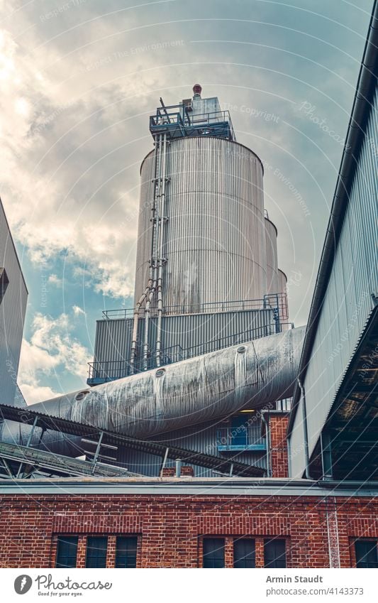 drei Silos und ein großes Rohr einer Fabrik mit dramatischem Himmel Architektur Gebäude Business Wolkenlandschaft Konstruktion Energie Einrichtung HDR