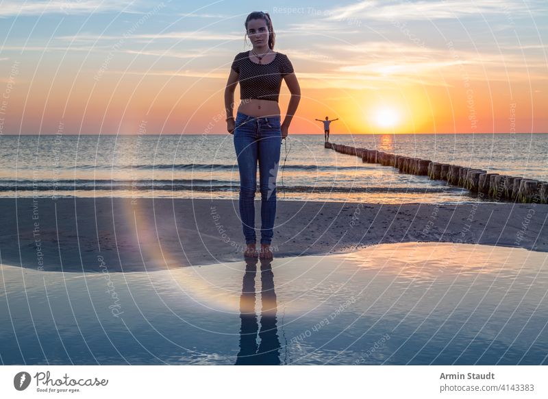 Sonnenuntergang über der Ostsee, Porträt einer jungen Frau, die am Strand steht Ausgewogenheit schön Schönheit Junge Abenddämmerung weit Freiheit Mädchen Leiste