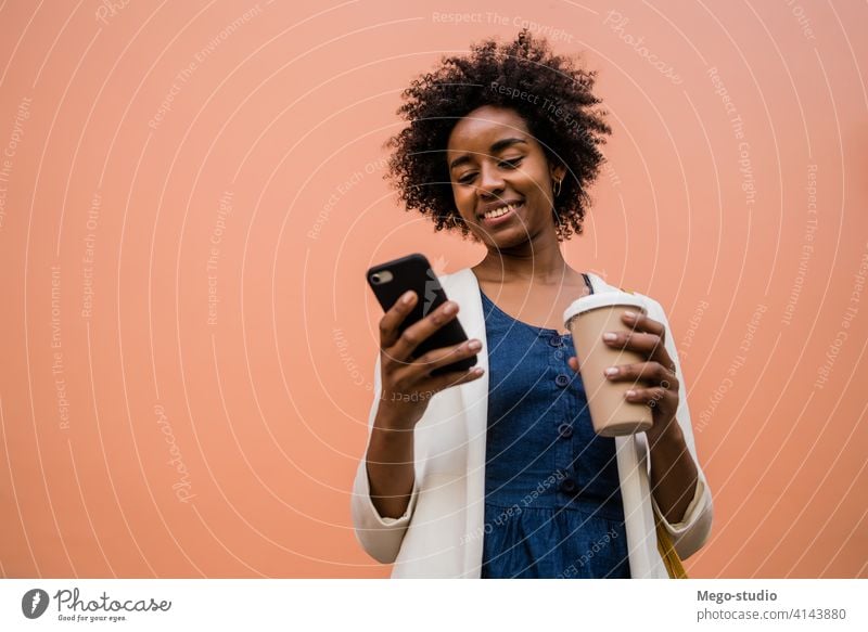 Geschäftsfrau, die ihr Mobiltelefon im Freien benutzt. Afro-Look Business Frau Mobile Telefon schwarz modern Stil brünett Apparatur positiv Konzept Anschluss