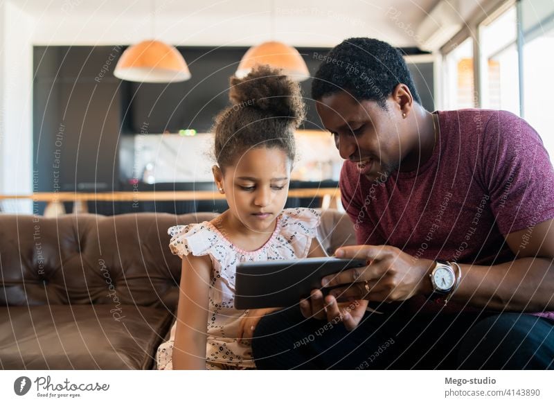 Vater und Tochter verwenden digitales Tablet zu Hause. monoparentiell spielen digitales Tablett Lifestyle Familie alleinerziehend im Innenbereich Aktivität