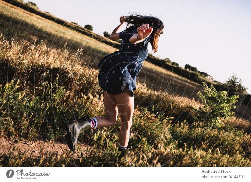 Fröhliche Frau läuft über ein Feld laufen Landschaft sorgenfrei Wochenende Sommer sonnig Freiheit heiter Gummi Stiefel Kleid Sonne Freude Wiese Natur Harmonie