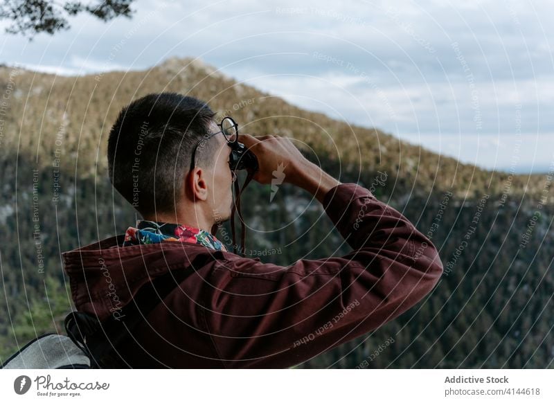 Wanderer mit Fernglas genießt die Aussicht vom Berg Mann Wanderung Berge u. Gebirge Hügel Wald erkunden reisen Aktivität Natur Trekking jung Fundstück Abenteuer