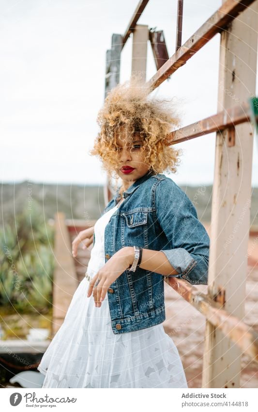 Stilvolle ethnische Frau auf alter Brücke Grunge trendy Mode schäbig Reling selbstbewusst Afroamerikaner schwarz charmant Lächeln Inhalt Windstille Freude