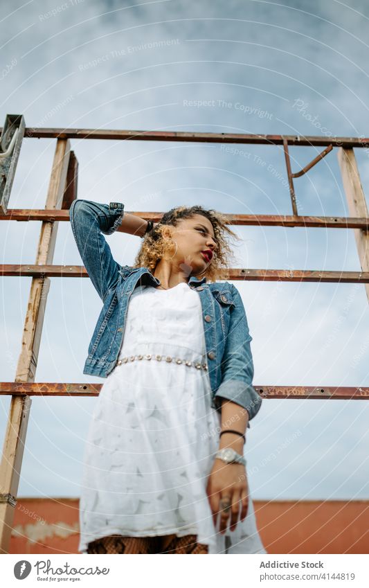 Stilvolle ethnische Frau auf alter Brücke Grunge trendy Mode schäbig Reling selbstbewusst Afroamerikaner schwarz charmant Lächeln Inhalt Windstille Freude