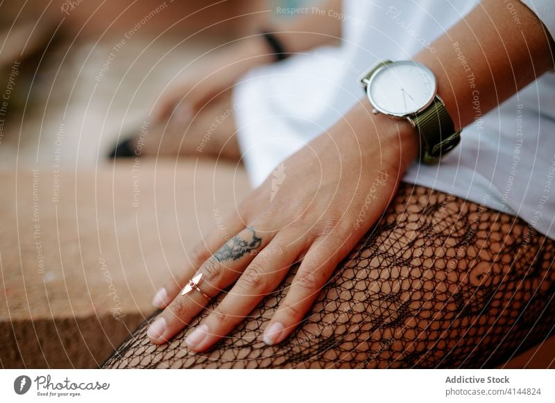 Crop-Frau mit Tattoo am Finger tausendjährig Tier Form brutal außergewöhnlich unabhängig Generation Großstadt urban Straße sitzen Stil zeigen manifestieren