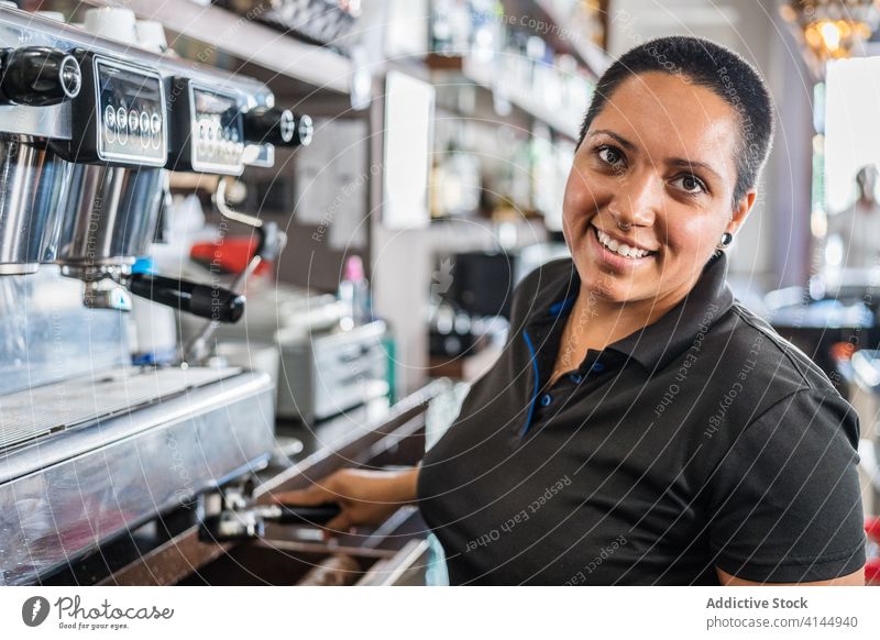 Weiblicher ethnischer Barista bereitet Kaffee in einer Kaffeemaschine zu Frau Dienst Mitarbeiter professionell Getränk Maschine Job Café eingießen Tasse