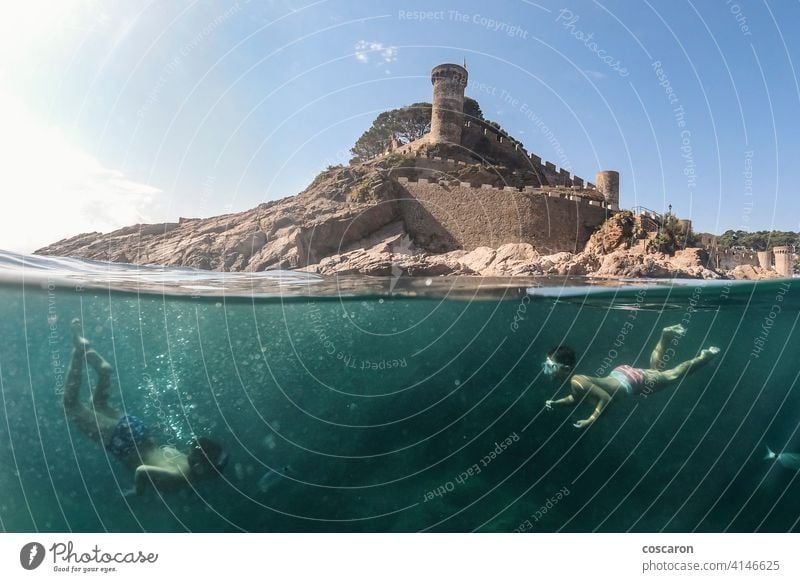 Zwei kleine Jungen schnorcheln mit einer Burg im Hintergrund Apnoe Strand Karibik Burg oder Schloss Kind Kindheit niedlich Sinkflug Taucher genießend Genuss