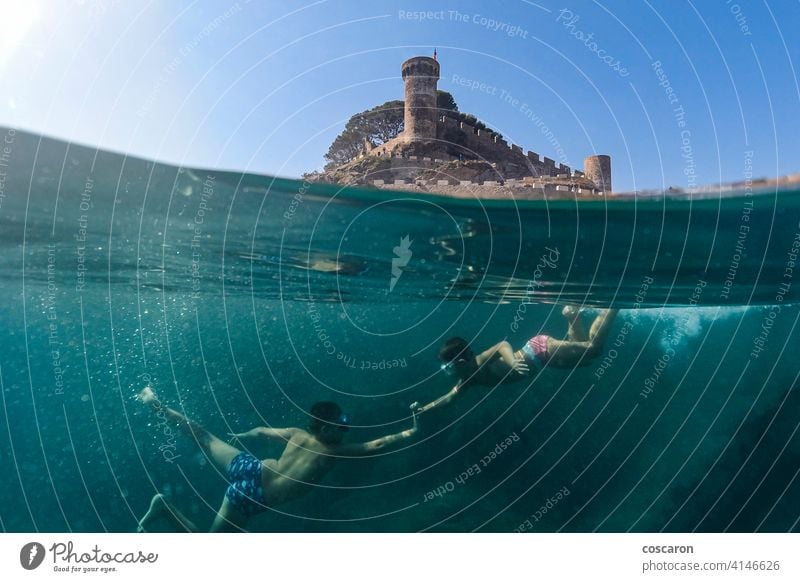 Zwei kleine Jungen schnorcheln mit einer Burg im Hintergrund Apnoe Strand Karibik Burg oder Schloss Kind Kindheit niedlich Sinkflug Taucher genießend Genuss