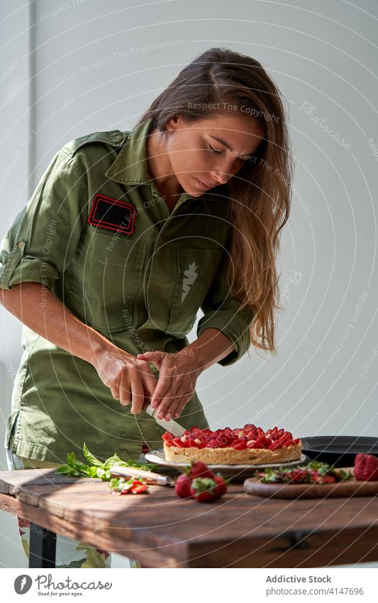 Hausfrau schneidet leckeren Beerenkuchen zu Hause aus geschnitten Pasteten selbstgemacht Frau Messer Dessert Windstille Koch Kuchen frisch süß Rezept