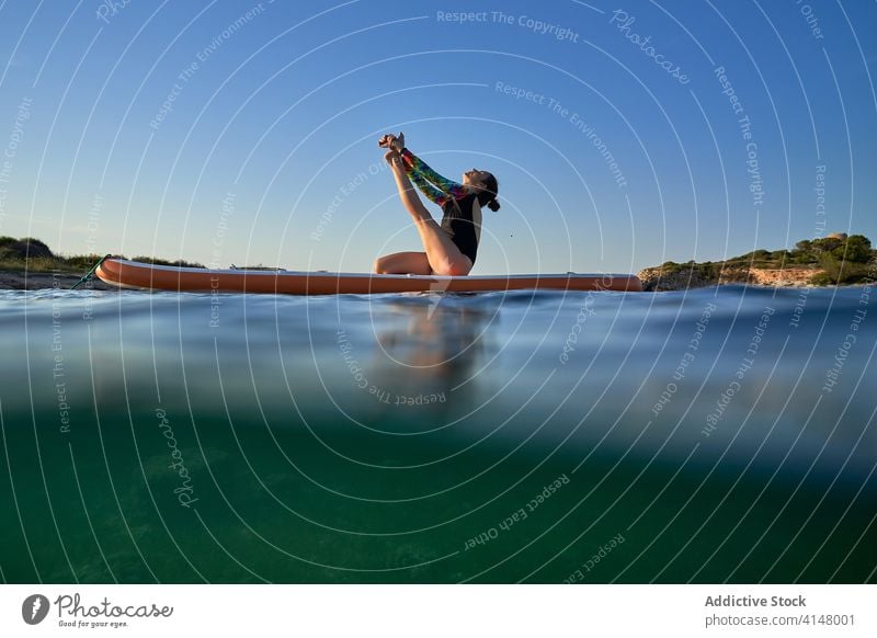 Flexible Frau macht Yoga auf Paddleboard Sonnenuntergang Pose Surfer Paddelbrett Gleichgewicht MEER Wasser Gesundheit Natur Harmonie sich[Akk] entspannen ruhig