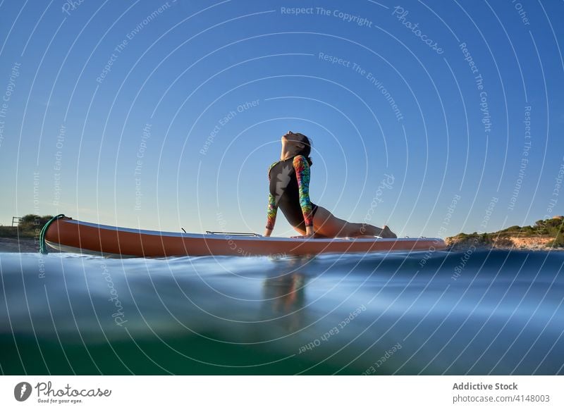 Flexible Frau macht Yoga auf Paddleboard Sonnenuntergang Pose Surfer Paddelbrett Gleichgewicht MEER Wasser Gesundheit Natur Harmonie sich[Akk] entspannen ruhig