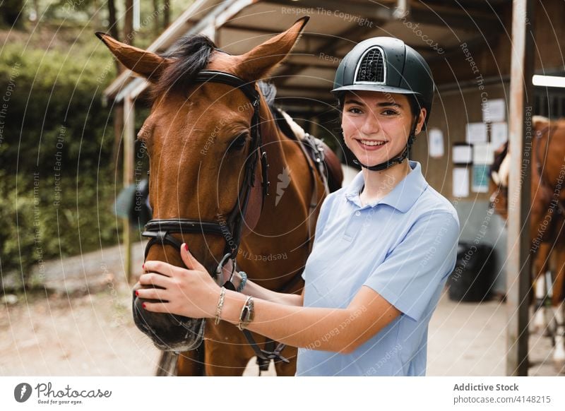 Begeisterte Reiterinnen mit Kastanienpferd Pferd Frau Ranch Zusammensein Jockey Landschaft heiter Tier Uniform Zaumzeug Zügel Gerät pferdeähnlich jung Besitzer