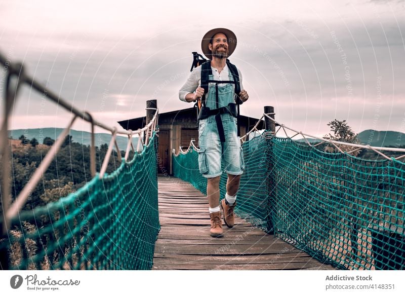 Reisender Mann zu Fuß entlang Holzsteg Suspension Steg Tourist Spaziergang Rucksack bewundern Landschaft hölzern Urlaub männlich Abenteuer Ausflug Tourismus