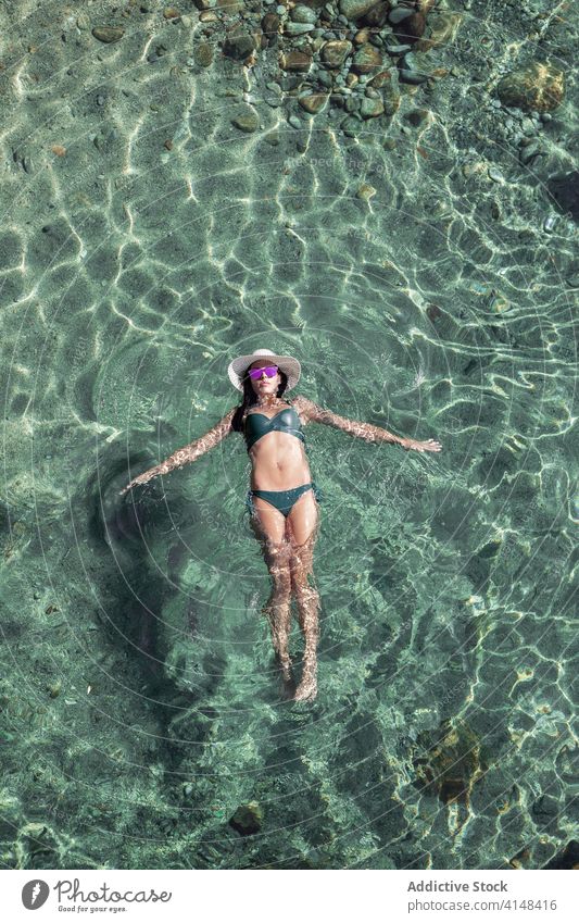 Frau schwimmt in sauberem Wasser schwimmen Resort Sauberkeit Ufer durchsichtig Sommer schlank Badebekleidung Küste ruhen idyllisch Urlaub sich[Akk] entspannen