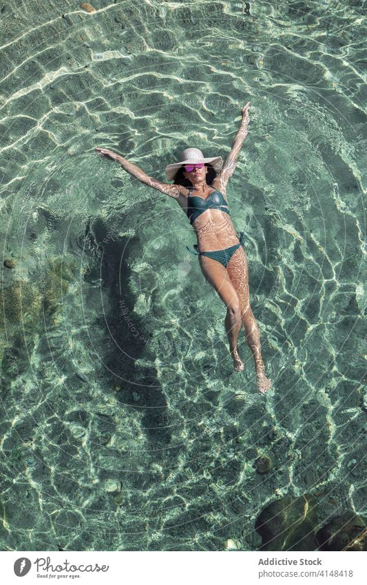 Frau schwimmt in sauberem Wasser schwimmen Resort Sauberkeit Ufer durchsichtig Sommer schlank Badebekleidung Küste ruhen idyllisch Urlaub sich[Akk] entspannen