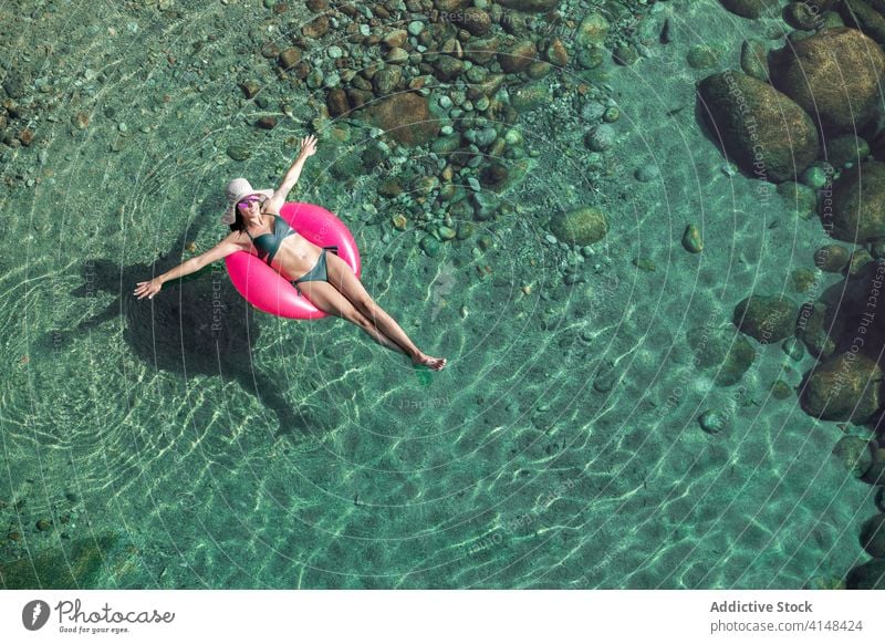 Frau schwimmt im Wasser mit Ring schwimmen Urlaub Resort Sommer Badebekleidung Sonnenbrille durchsichtig aufblasbar Tube sonnig tagsüber sich[Akk] entspannen