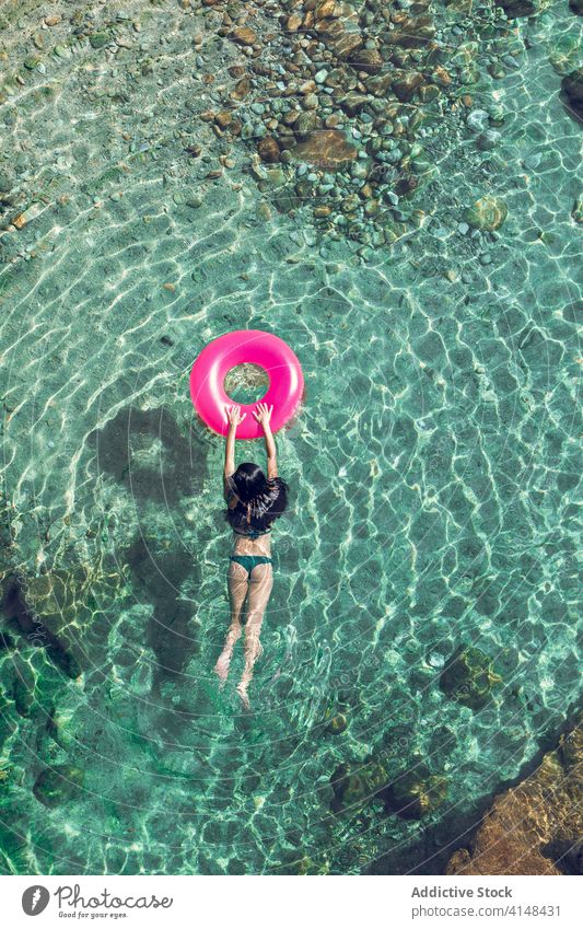 Frau schwimmt im Wasser mit Ring schwimmen Urlaub Resort Sommer Badebekleidung Sonnenbrille durchsichtig aufblasbar Tube sonnig tagsüber sich[Akk] entspannen