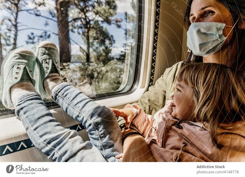 Mutter und Tochter im Zug reisen Fenster Kind Zusammensein Coronavirus Mundschutz behüten Passagier Sitz wenig Mädchen Reise Seuche medizinisch Windstille