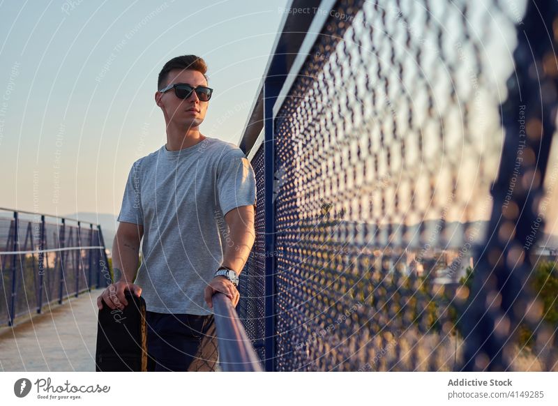 Seriöser Mann mit Gitarre in der Stadt Musiker Gitarrenspieler Großstadt Brücke Windstille ernst Talent Spieler männlich Fall selbstbewusst gutaussehend