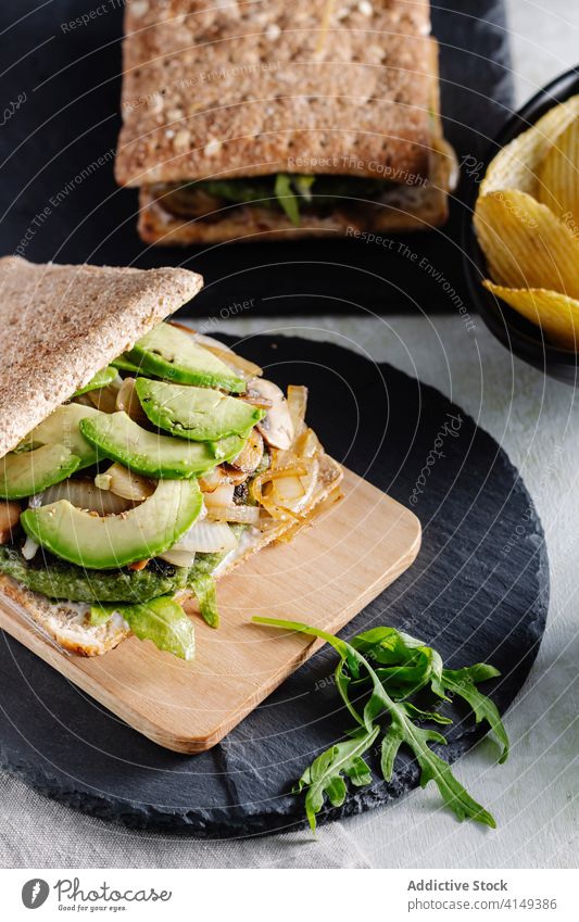 Leckeres Sandwich und Bier auf dem Tisch Belegtes Brot Avocado Snack Amuse-Gueule lecker Chip Kartoffel Alkohol Glas Lebensmittel Mahlzeit trinken Getränk