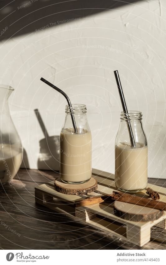 Flaschen mit Milchshake auf Holztisch selbstgemacht Gesundheit Zimt Lebensmittel trinken frisch Frühstück Getränk natürlich geschmackvoll Dessert süß Glas