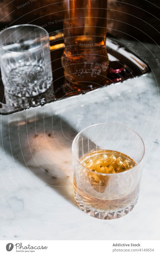 Glas mit alkoholischem Getränk auf Marmortisch Whiskey Bar Alkohol trinken Flasche dienen Abfertigungsschalter Schnaps Erfrischung Tisch Pub durchsichtig modern