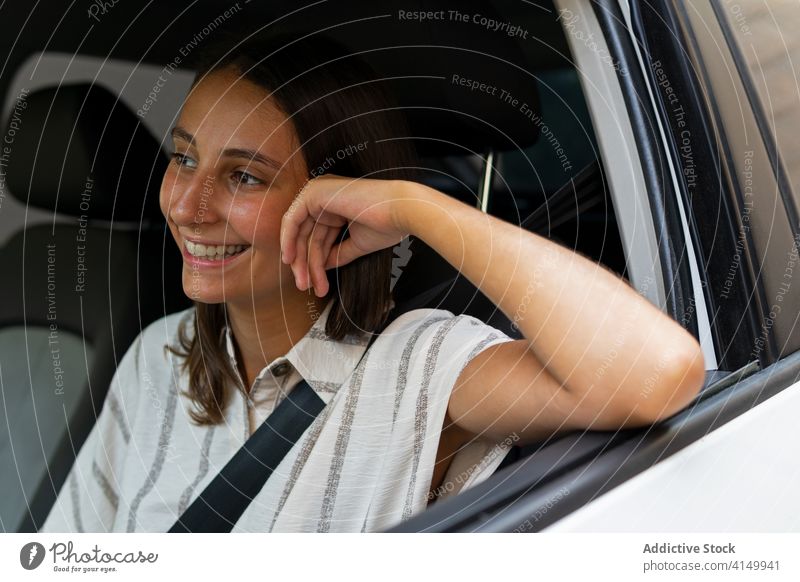 Fröhliche Frau fährt Auto in der Stadt Laufwerk PKW Automobil Fahrer Großstadt Verkehr Lächeln jung Sitz tagsüber modern Glück heiter Fahrzeug Freude sitzen