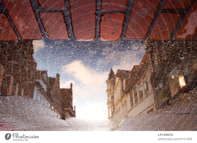 Lüneburger Einkaufsmeile Pfütze Stadt Spiegelung im Wasser Pfützenfoto Haus Altstadt Gebäude Städtereise Einkaufsstraße Boden surreal Backstein Regen wohnen