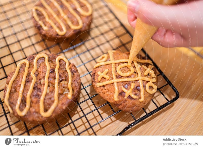 Anonymer Bäcker, der zu Hause Kekse backt backen heimwärts Biskuit Karamell Backwarenbeutel Saucen Belag Schokoladensplitter Küche Lebensmittel kulinarisch