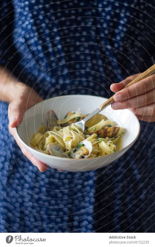 Crop-Frau isst leckere Spaghetti mit Venusmuscheln Tagliatelle alle vongole Speise Muschel genießen essen Schalen & Schüsseln Tradition geschmackvoll