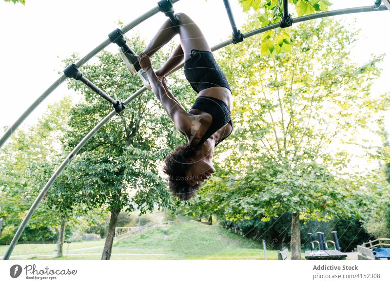 Fitte Frau beim Training auf dem Sportplatz Fitness Laufmasche hängen sportlich Übung Sportpark Gerät jung Afroamerikaner schwarz ethnisch passen Park