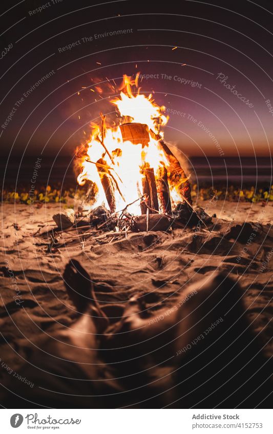 Männlicher Reisender entspannt sich am Strand in der Nähe des Lagerfeuers Freudenfeuer Mann Sonnenuntergang MEER Campingplatz Meeresufer Tourist männlich Urlaub