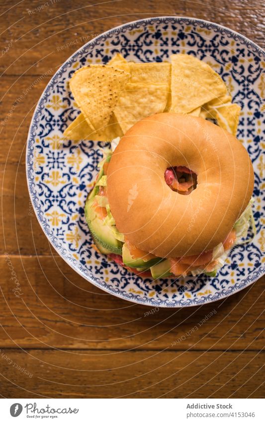 Leckerer Lachs-Bagel auf dem Teller in der Küche geschmackvoll lecker Speise Lebensmittel Mahlzeit Mittagessen Tomate Weinstein hölzern Tisch alioli Rübe