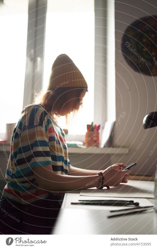 Handwerkerin mit Smartphone in der Werkstatt Künstler Browsen Frau benutzend ausgefallen Atelier Talkrunde Mobile Telefon Arbeit online sich[Akk] entspannen