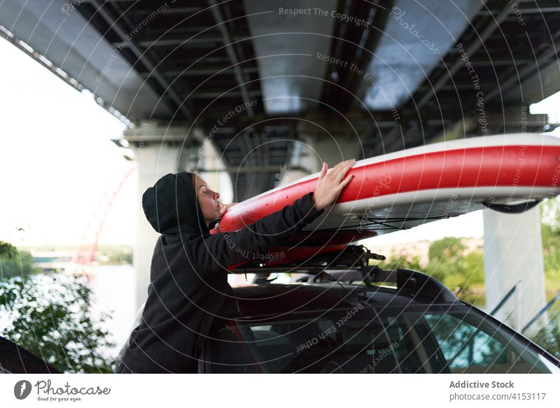 Ernste Frau mit Paddelbrett in der Nähe des Autos Surfer PKW Windstille Automobil sich[Akk] entspannen Surfbrett Holzplatte Surfen Sport Sommer Athlet ruhig