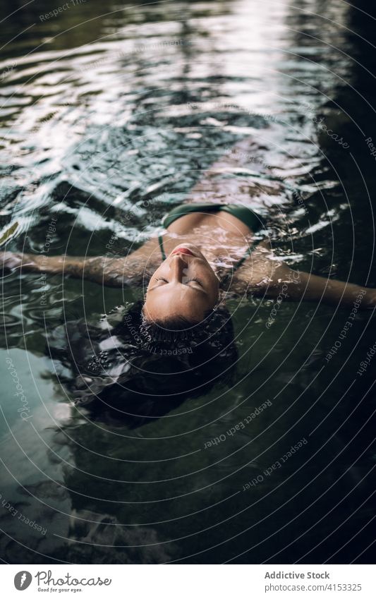 Serene Frau schwimmend auf See Wasser Schwimmer genießen Urlaub Gelassenheit sich[Akk] entspannen Teich Bikini Sommer Lügen Augen geschlossen Badebekleidung