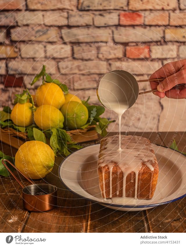 Kochen Gießen Glasur über Zitrone Kuchen Mohn eingießen gebacken Gebäck süß Dessert vorbereiten Zuckerguß Lebensmittel selbstgemacht frisch Hand Küche lecker