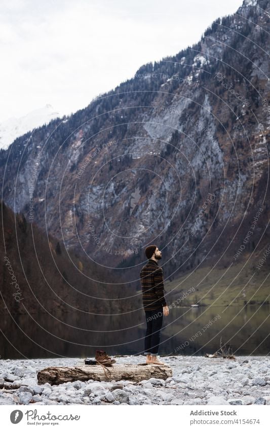 Mann stehend am Seeufer gegen Berge im Herbsttag Berge u. Gebirge Landschaft reisen Gipfel Schnee Wald Windstille friedlich majestätisch männlich Tourismus