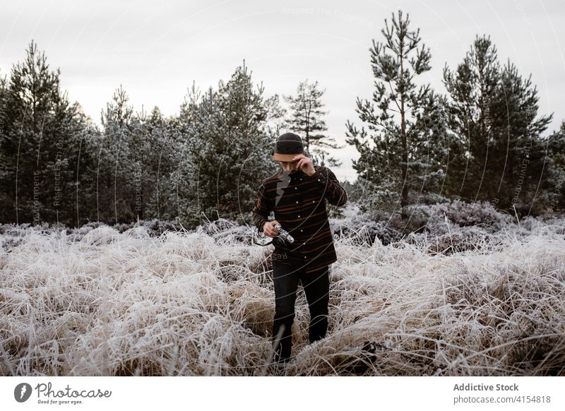 Männlicher Fotograf im gefrorenen Feld im Winter Mann Schnee Frost Fotoapparat Wiese Saison männlich Schottisches Hochland Natur Gras kalt Urlaub weiß Wetter