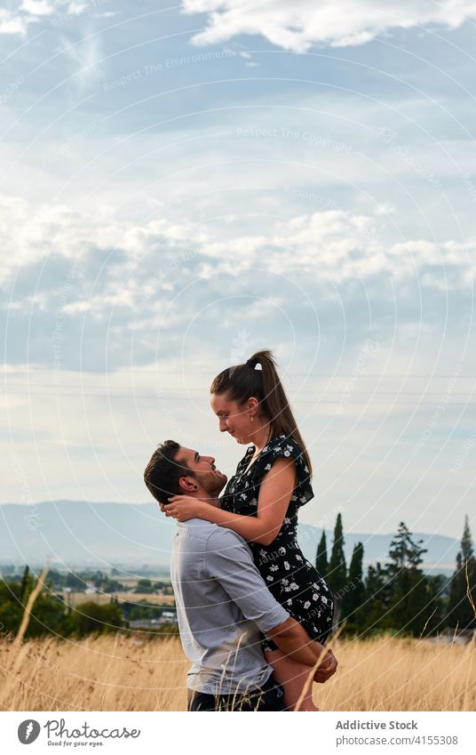 Vergnügtes Paar auf einem Feld im Sommer heben Liebe Zusammensein Partnerschaft verliebt Umarmung Wiese Freundin Glück romantisch sich[Akk] entspannen Zuneigung