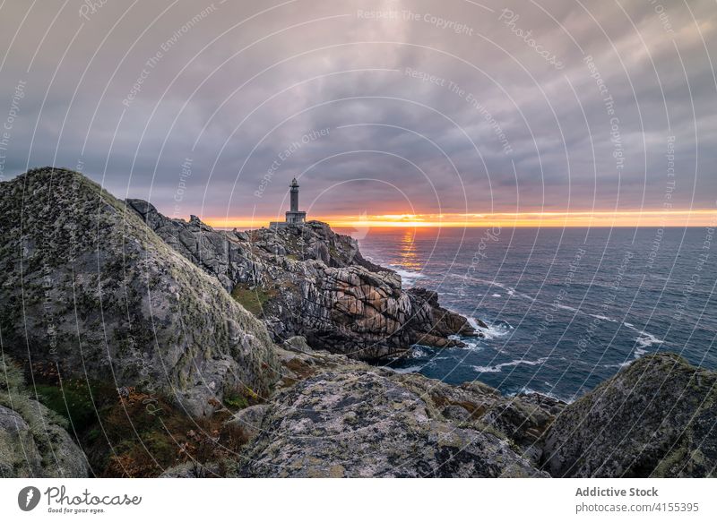 Leuchtfeuer auf felsigem Hügel bei Sonnenuntergang Leuchtturm Klippe Landschaft Himmel MEER rau spektakulär Küste Abenddämmerung malerisch atemberaubend Felsen