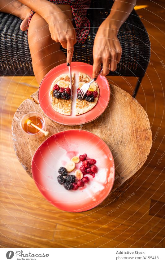 Anonyme Frau isst gesunde Pfannkuchen zum Frühstück Teller süß frisch geschmackvoll Gesundheit Frucht lecker Himbeeren Liebling organisch Lebensmittel Beeren