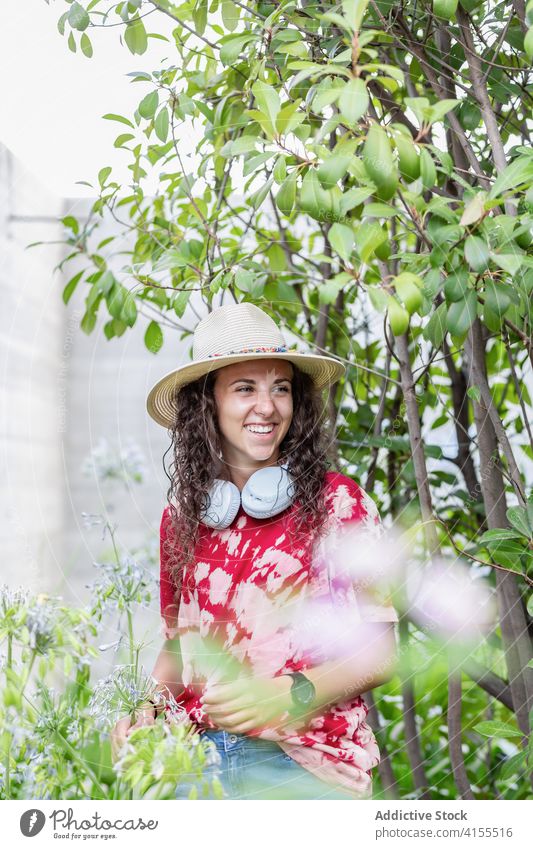 Fröhliche stilvolle Frau mit Kopfhörern im Park Stil Hipster Glück heiter modern tausendjährig urban jung lässig Zeitgenosse Apparatur Gerät trendy Lifestyle