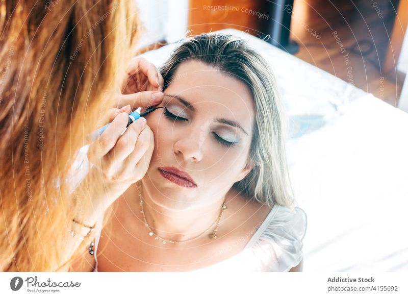 Crop Visagistin beim Auftragen von Make-up im Salon Kajal bewerben professionell Kosmetik dekorativ Prozess Leckerbissen Schönheit Vorschein Model Windstille