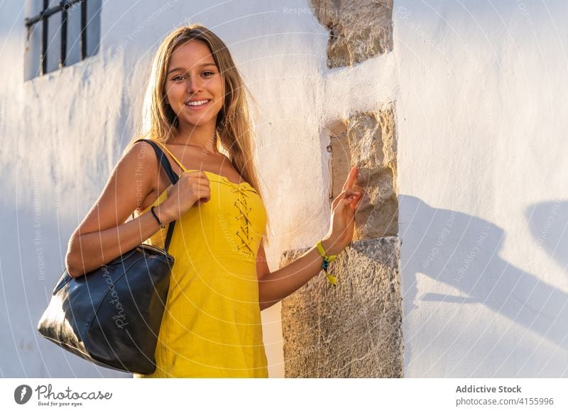 Zufriedene Frau im Kleid in der Nähe eines Gebäudes Großstadt Tourist Sommer Sonnenlicht Urlaub historisch Stadt sonnig Wand Stein reisen Straße Freude Feiertag